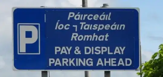 Sign saying "Páırceáıl Íoc ⁊ Taıspeáın Romhat — PAY & DISPLAY PARKING AHEAD"