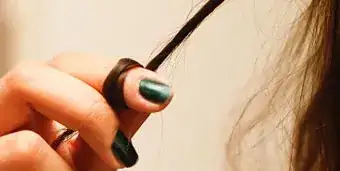 close-up of a woman's finger twirling a lock of hair