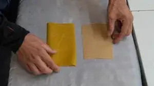 <strong>Bügelschritt 1:</strong> Die doppelseitige Textilklebefolie mit der Folienseite auf die linke Stoffseite legen und aufbügeln. Für das Aufbügeln die Anleitung des Herstellers der Textilklebefolie befolgen. Abkühlen lassen.