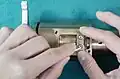 2. Remove the two screws and lift off the gear wheel assembly.