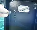 2. Raise the left side of the machine and support on a block. Using a 4 mm wrench remove the rearmost M5 x 25 mm screw fastening the gear carrier to the chassis.