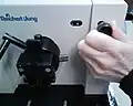 12. Remove the support block. Remove the section thickness knob and shaft by pulling out. The shaft is held in the dial by a spring loaded ball.