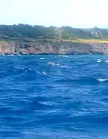 Two of the guns and the red flag can be discerned in this grainy long shot from the Fathom. Note the right angled triangle in the cliff below and to the left as a marker.